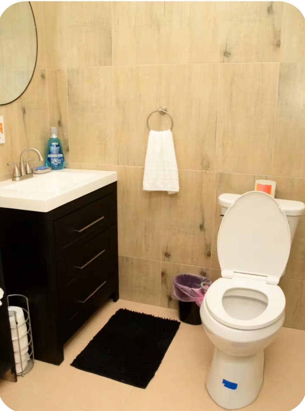 Clean bathroom with wood-look tile walls and modern fixtures