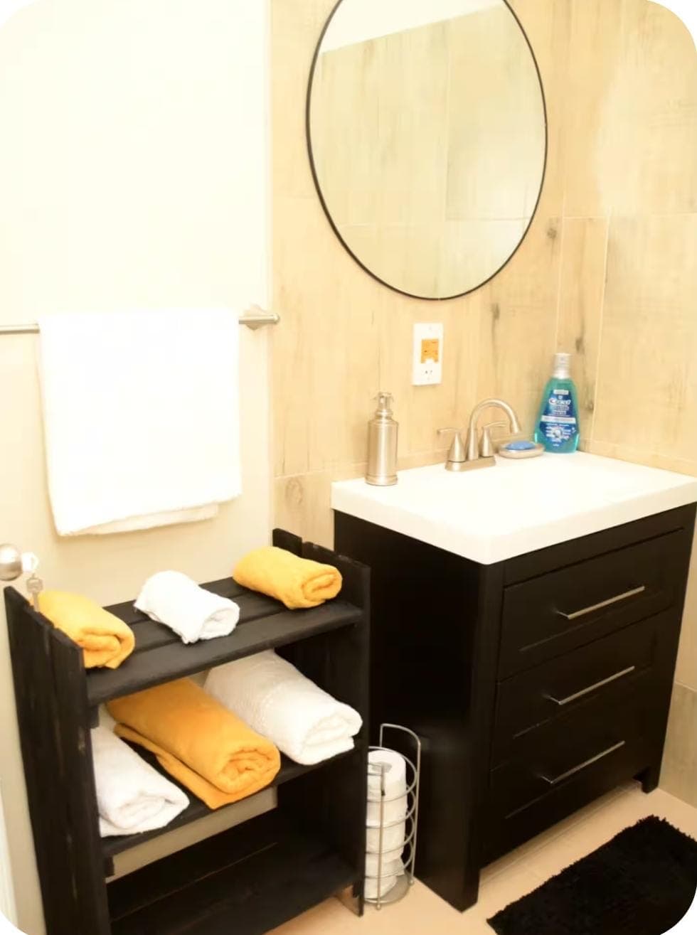 Bathroom vanity with gold and white towels neatly arranged