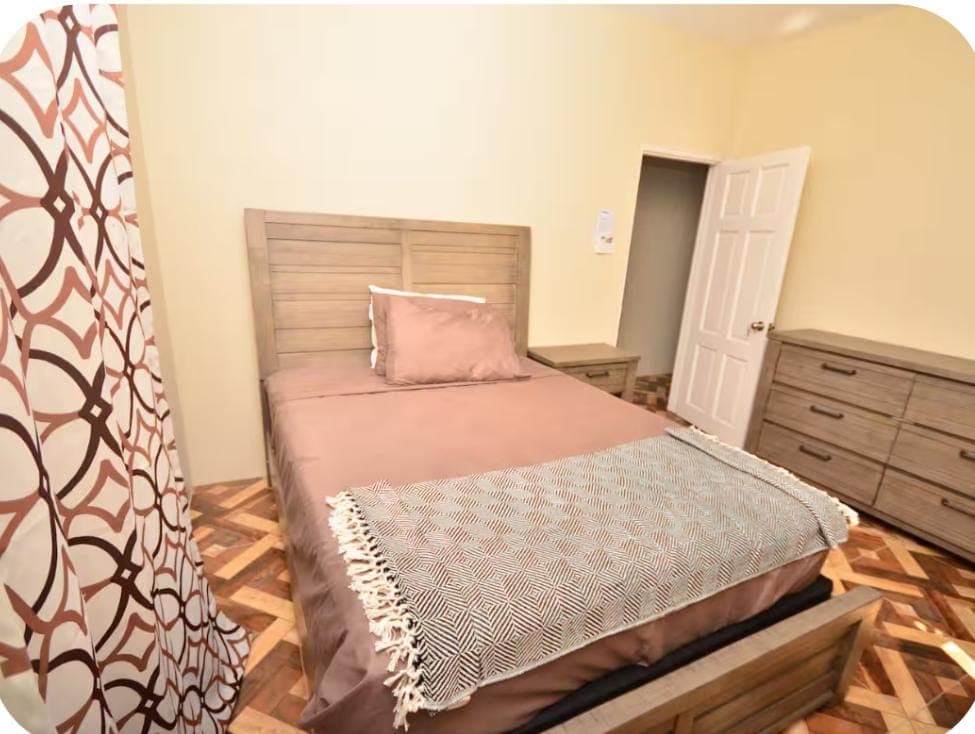 Master bedroom alternate view with dresser and en-suite door