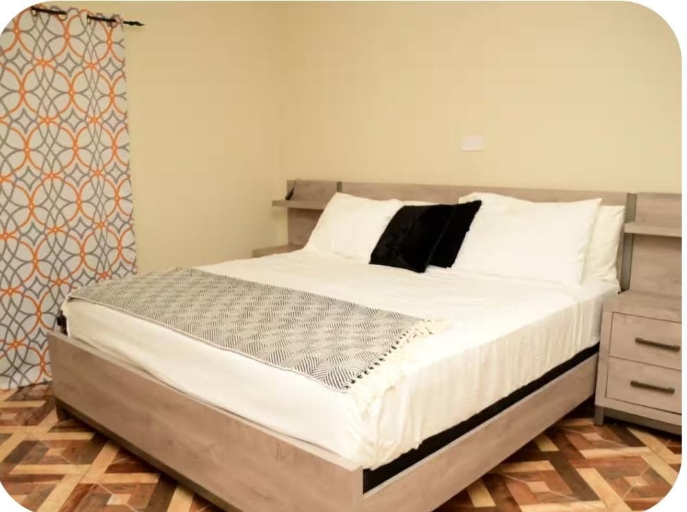 Close-up of comfortable king bed with decorative throw