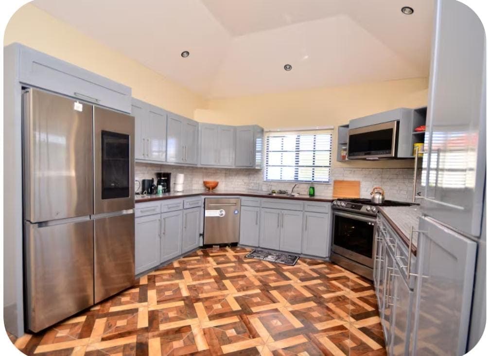 Modern U-shaped kitchen with grey cabinets and stainless steel appliances